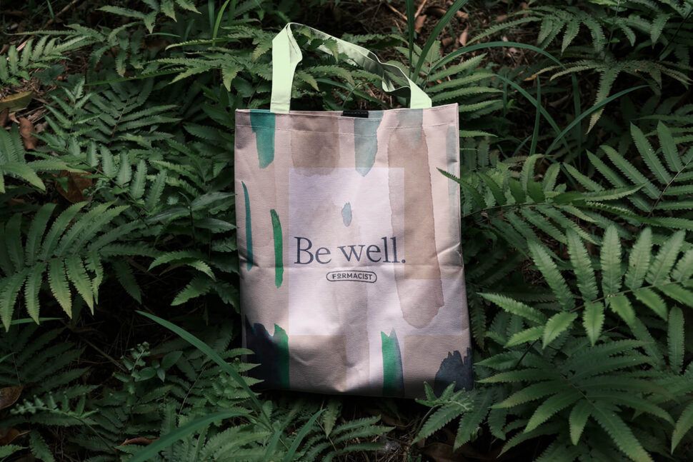 Tote bag against lush ferns